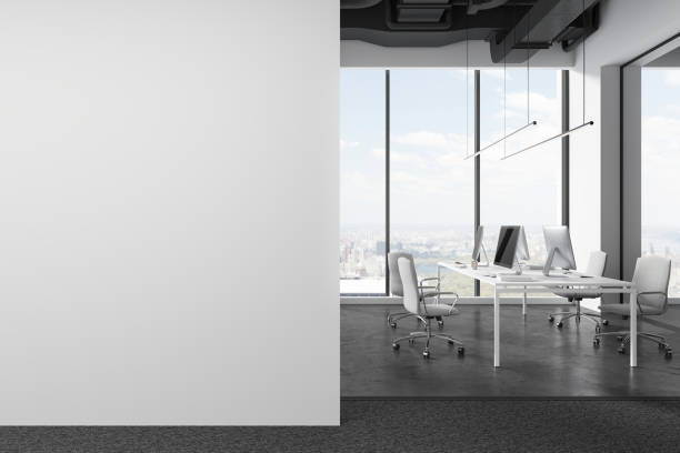 istock Business coworking interior with pc monitors on table and chairs, mock up wall 1830018338