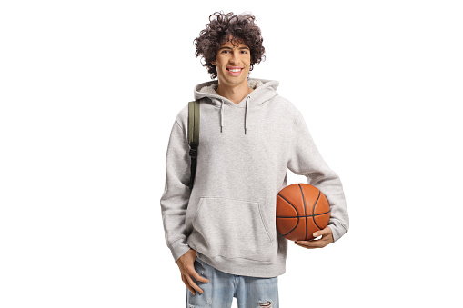 Smiling young man with a basketball and a backpack isolated on white background