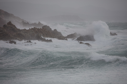 Gusty winds and huge waves hitting the massive granite boulders of the cape, dubbed Capo Testa, close to Santa Teresa Gallura, in Sardinia. The perilous sea comprised in the narrow strait Bocche di Bonifacio, between Corsica and Sardinia, is showing off all its intimidating power