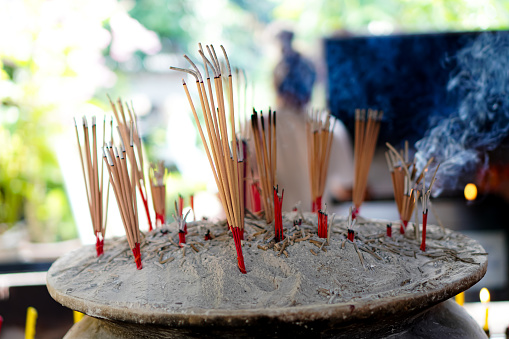 Incense was lit by the fire of candle for Buddhist pray for benefaction worship to Buddha at Thai or Chinese temple.