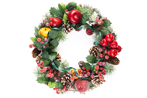 Top view of a christmas wreath with ornaments such as a candy cane, christmas balls, berries and christmas lights isolated on white background