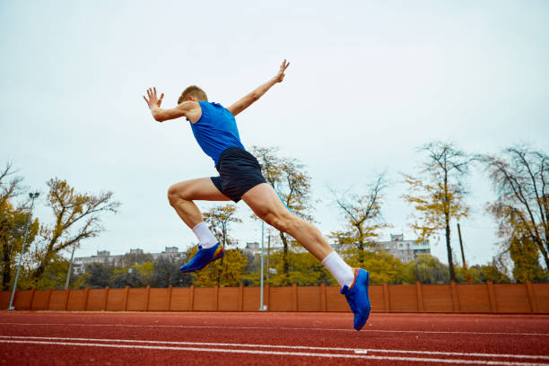 istock Dynamic steps leading to an impactful long jump. Bottom view full length portrait of professional sportsman running on sport field. 1830046633