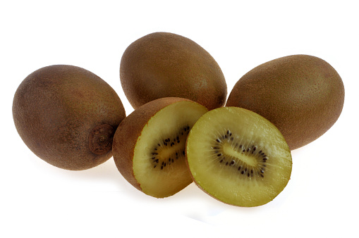 Stock photo showing a close-up view of healthy eating image of a group of Chinese gooseberry (kiwi), one cut in half displaying bright green flesh with ring of black seeds.