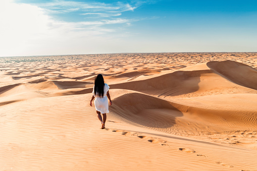 Dubai dessert sand dunes, Asian woman on Dubai desert safari, United Arab Emirates vacation, woman vacation in Dubai