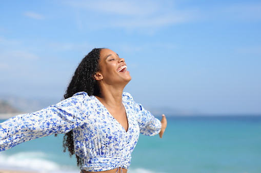 Joyful black woman celebrating on the beach