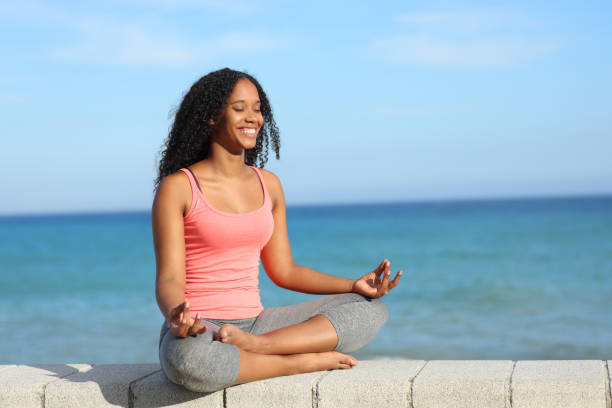 istock Happy black yogi doing yoga exercise on the beach 1830061276