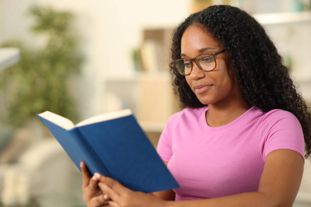 istock Black woman wearing eyeglass reading book 1830062906