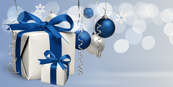 Christmas and New year greeting card or banner with presents and blue balls, baubles on light blue background. Copy space