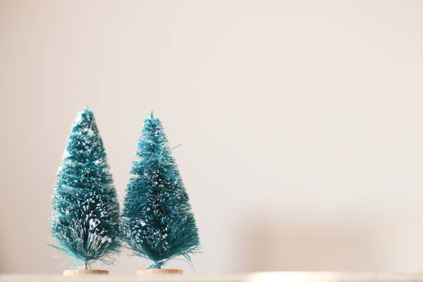 istock Two green Christmas trees on a light background. Christmas background. 1830073838