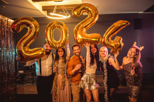 Group of young people celebrating New Year at the nightclub. Group of younge people celebrating New Year at the nightclub. They are holding gold number ballons 2024 30 stock pictures, royalty-free photos & images