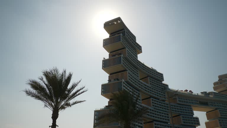 day time dubai city palm island most famous new modern luxury hotel exterior front sun light slow motion panorama 4k uae