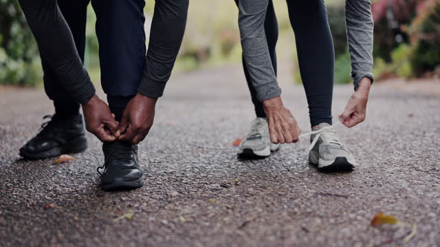 People, hands and sneakers, tie shoelace and start run, fitness and cardio with couple of friends outdoor. Sport, health and exercise in street, closeup of shoes with runner ready for workout or race