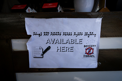 A 'Boycott Israel' sign on display inside of a cafe in Malé. Daily life in Malé, Maldives, the capital city of the island nation in the Indian Ocean, whose economy depends heavily on tourism. The country's population includes many foreign nationals working from nations worldwide, including the Philippines, Myanmar, Sri Lanka, and India, and its population is predominantly Muslim.