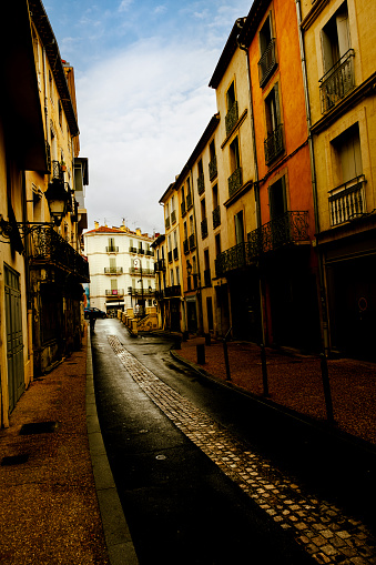 Dark alley in the town of Beziers in Southern France. There is a mysterious shadowy figure at the end of the alley.