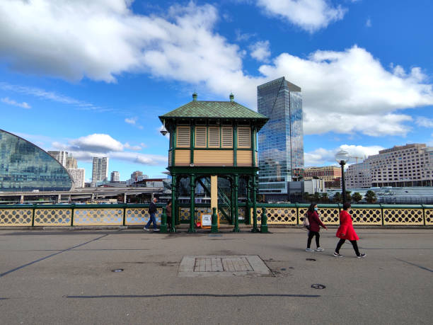 People walking on the Pyrmont Bridge, a heritage-listed swing bridge across Cockle Bay, located in Darling Harbour, part of Port Jackson, west of the central business district in Sydney, New South Wales, Australia.