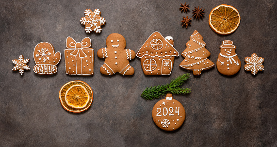 Christmas gingerbread cookies on a dark background. Top view, flat lay. New Year 2024. Banner.