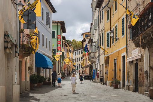 Asciano, Italy - August 30, 2023: Main street and old town centre of the quaint and charming, historic Tuscan village of Asciano, Tuscany.
