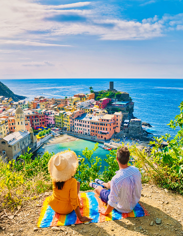 A couple of caucasian men and Asian women are on the hill looking out over the bay of Vernazza village Cinque Terre National Park Italy, The picturesque coastal village of Vernazza Cinque Terre