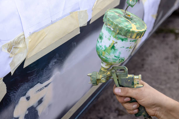 istock Technician spraying car primer paint on a prepared surface. 1830138554