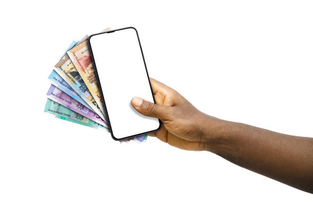 istock Black hand holding mobile phone with blank screen and 2022 Jamaican dollar notes 1830159915