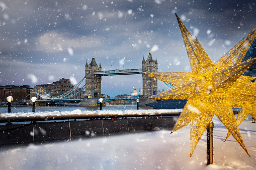 Festive christmas decorations in front of the Tower Bridge with snow