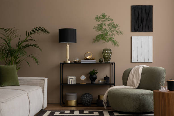 istock Warm and cozy living room interior with mock up poster frame, black rack, modular sofa, patterned rug, lamp, stylish sculpture, box, green armchair and personal accessories. Home decor. Template. 1830174545