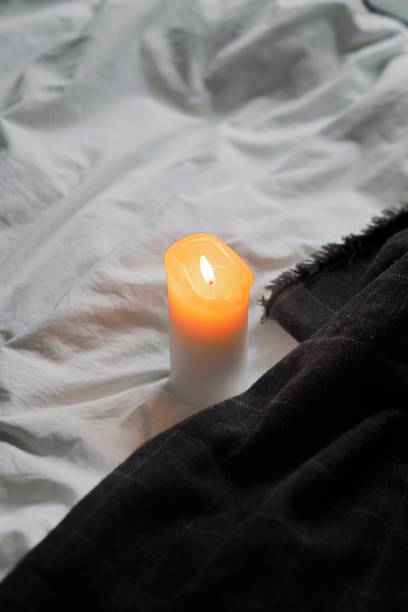 istock there is a candle on the bed and some blankets on it 1830182657
