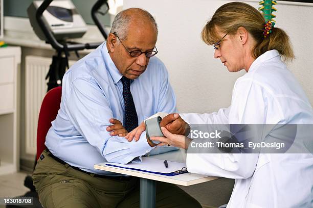 Doctor Revisando La Presión Sanguínea De Su Paciente Foto de stock y más banco de imágenes de Indicador de presión sanguínea