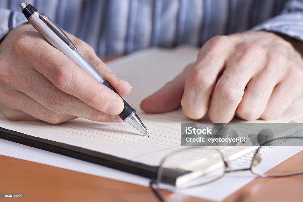 Businessman taking notes on pad Adult Stock Photo