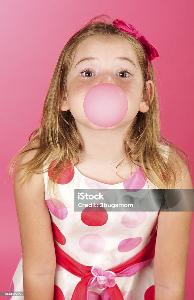 Ładny Dziewczyna z wzorem w kropki sukienkę i gumy balonowej - Zbiór zdjęć royalty-free (6-7 lat)