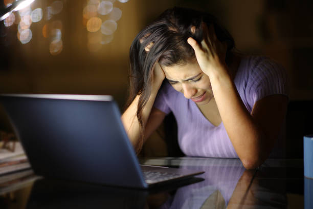 istock Sad woman complaining alone cheking laptop in the night 1830192030