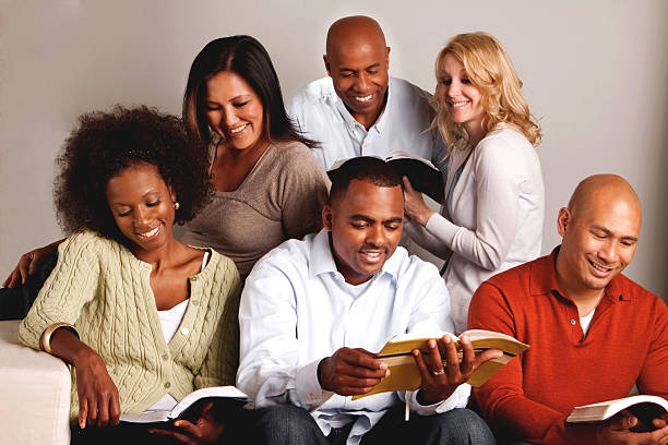 Diverse group of friends reading Diverse group of friends reading bible study group of people small group of people stock pictures, royalty-free photos & images