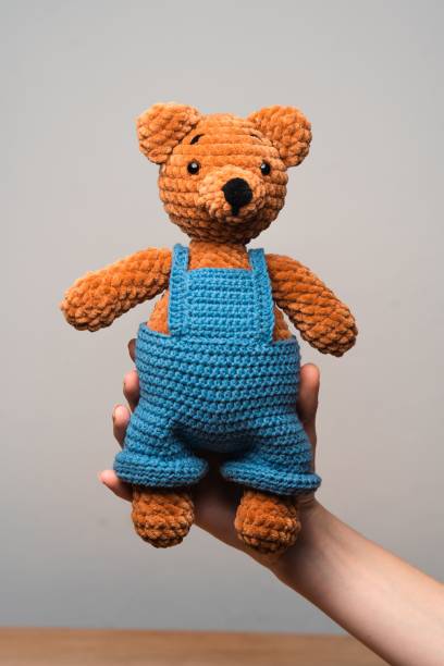 istock Young person holding a bright and cheerful teddy bear 1830194781