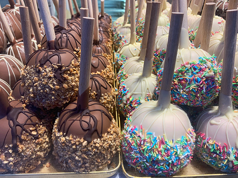Chocolate-covered apples on display at the Christmas market, featuring a rich layer of smooth chocolate and festive toppings, creating a tempting and indulgent holiday treat.