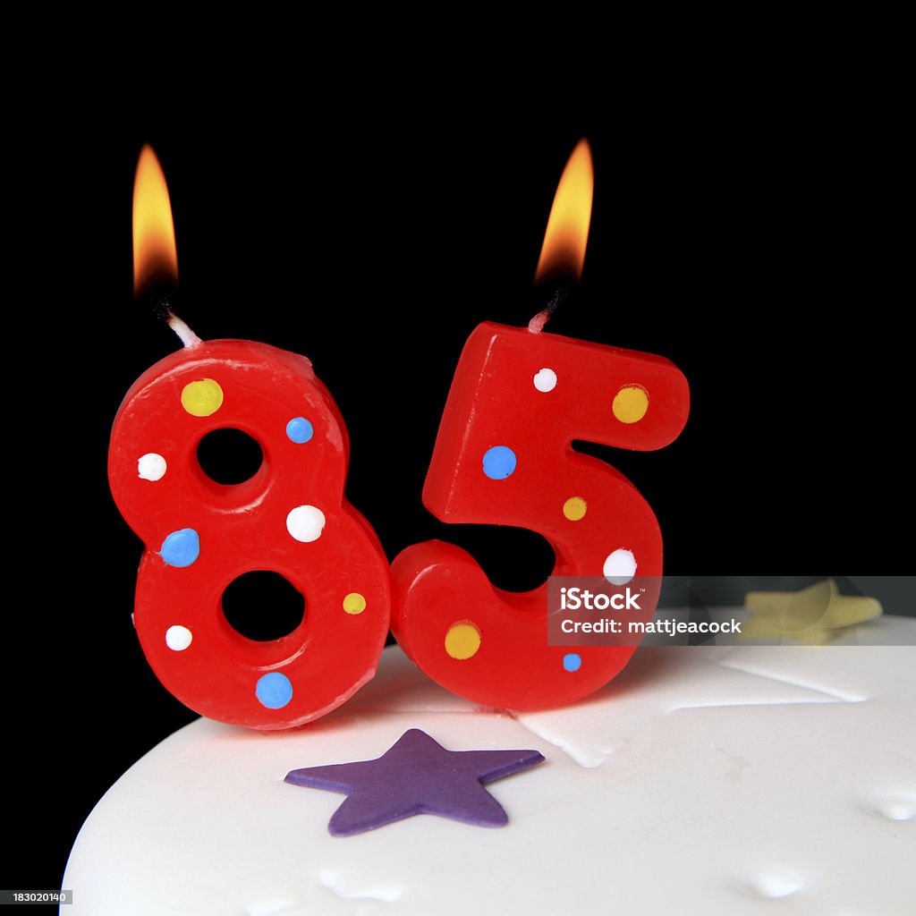 85th Birthday candles Red Birthday candles against black background Anniversary Stock Photo
