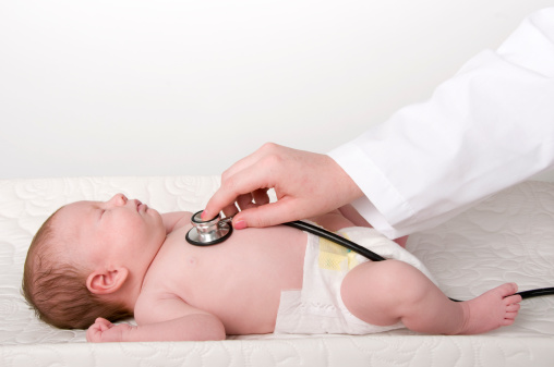Medical doctor checking the heart rate of an unresponsive infant with a stethoscope.View Similar Images: