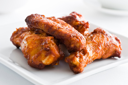 Red hot spicy chicken wings on a white background