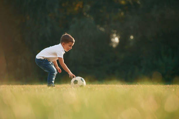 istock Side view, playing soccer. Little boy is playing outdoors at daytime 1830206619