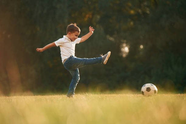 istock Side view, playing soccer. Little boy is playing outdoors at daytime 1830206636