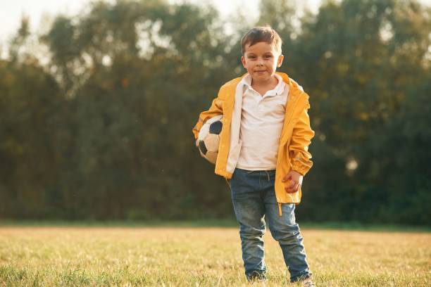 istock Standing with soccer ball. Little boy is playing outdoors at daytime 1830207218