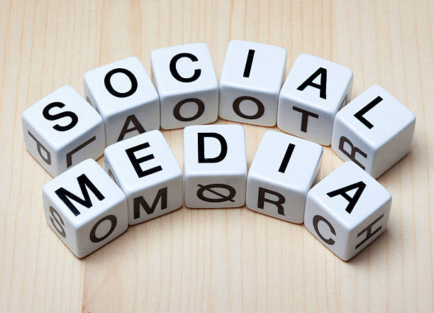 Word Social media spelled out on leisure game letter dices on wooden table top.