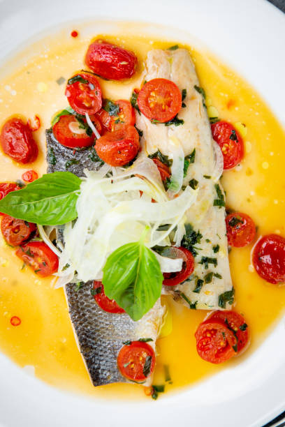 istock unpeeled fish with gravy, herbs, cherry tomatoes and onions, top view 1830210623