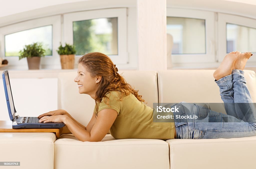 Mujer joven usando el ordenador en casa - Foto de stock de Descalzo libre de derechos