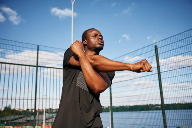 istock Doing fitness exercises. Handsome black man is posing outdoors at daytime 1830219408