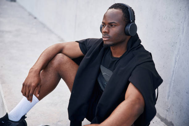istock With headphones. Handsome black man is posing outdoors at daytime 1830219655