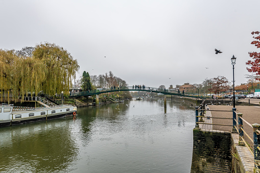 Twickenham, UK. 2 December 2023. People on the bridge that links to Eel Pie Island on River Thames in London.
