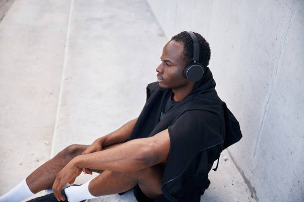 istock With headphones. Handsome black man is posing outdoors at daytime 1830219974