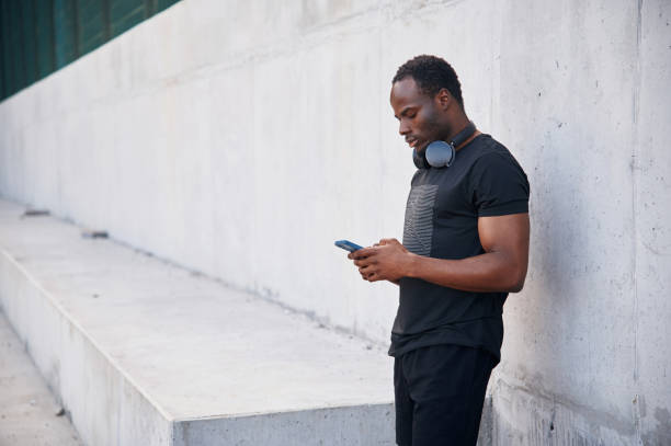 istock With headphones. Handsome black man is posing outdoors at daytime 1830219991
