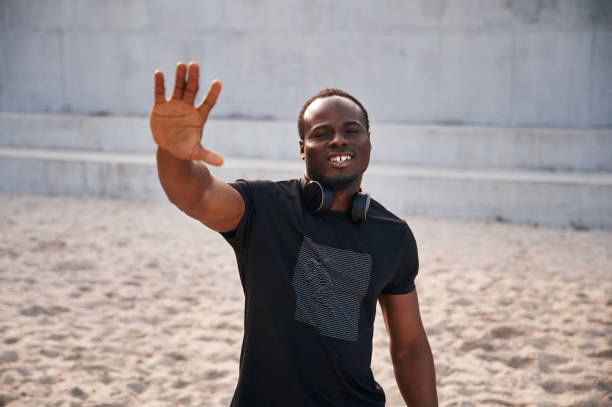 istock Greeting hand. Handsome black man is posing outdoors at daytime 1830221081