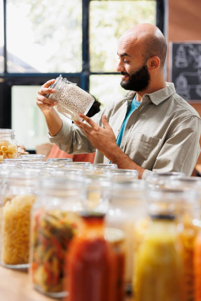 istock Man closely admires a filled glass jar 1830225032